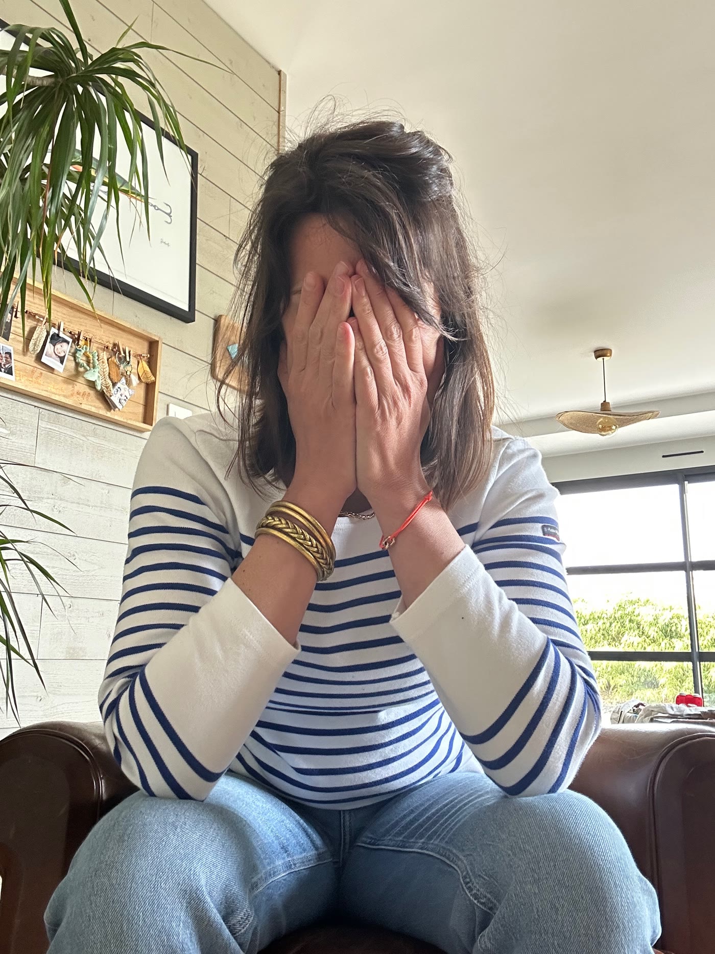 Femme assise, les mains sur le visage
